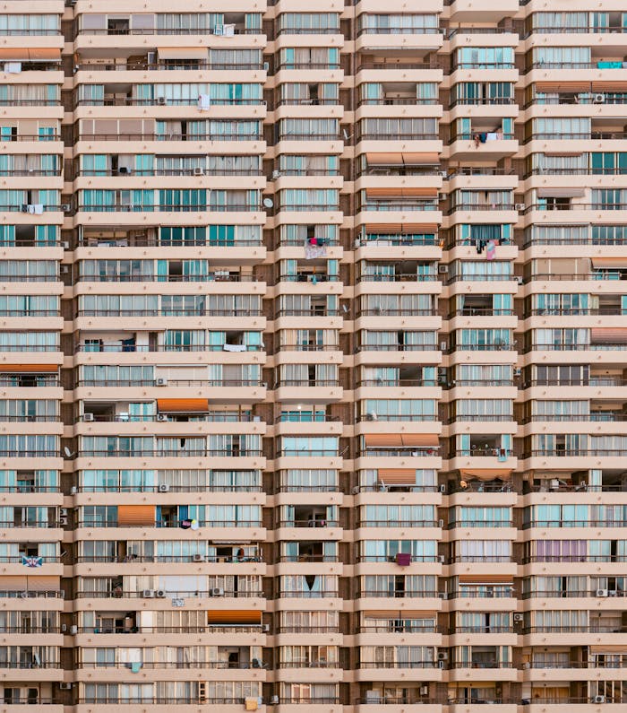pexels photo 14187410 1 Patterned facade of a residential high-rise in Benidorm, showcasing repetitive balconies and windows.